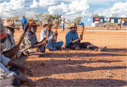Banjo and other senior men perform ceremonial song at the opening of Protest House.
